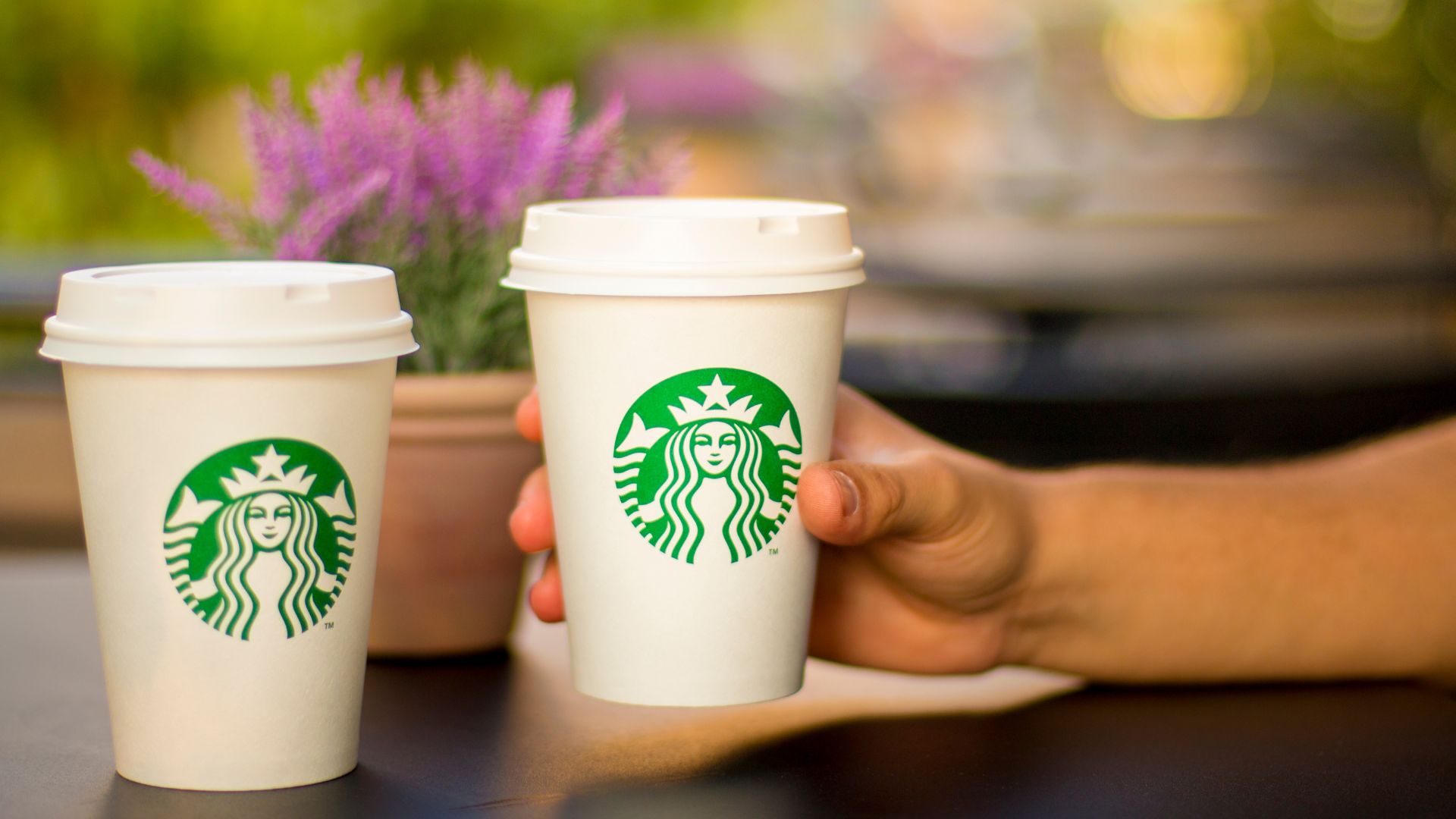 Two takeaway coffee cups with the Starbucks logo, symbolizing a successful loyalty program Caption: